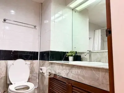 Modern bathroom with elegant marble tiles and sleek fixtures in a stylish real estate property.