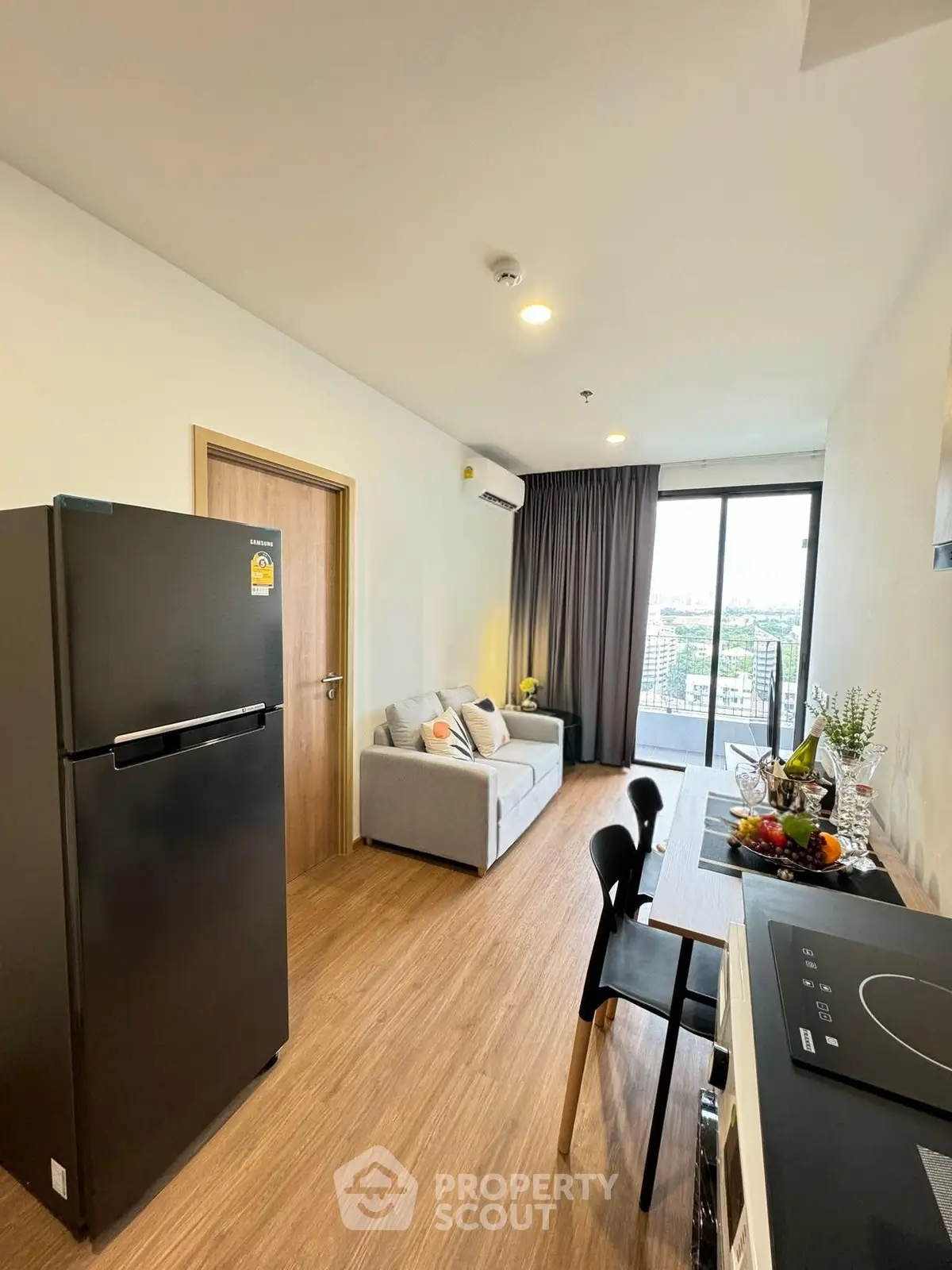 Modern living room with balcony view and sleek kitchen appliances