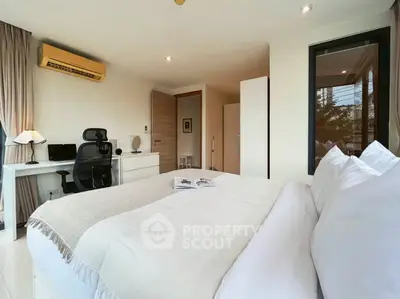 Spacious modern bedroom with desk and large window, perfect for comfort and productivity.