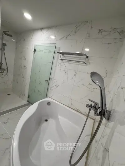 Luxurious bathroom with marble tiles and modern bathtub, perfect for relaxation.