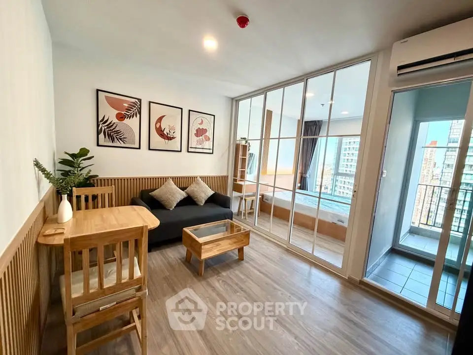 Modern living room with wooden furniture and glass partition leading to a cozy bedroom with city view.