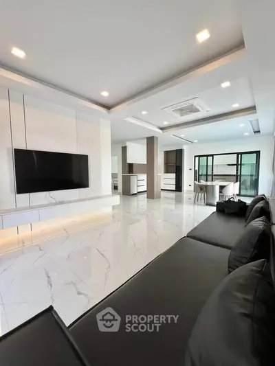 Luxurious modern living room with sleek design and marble flooring, featuring a large TV and stylish furniture.