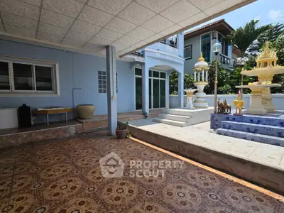 Spacious outdoor area with decorative elements and tiled flooring in a serene residential setting.