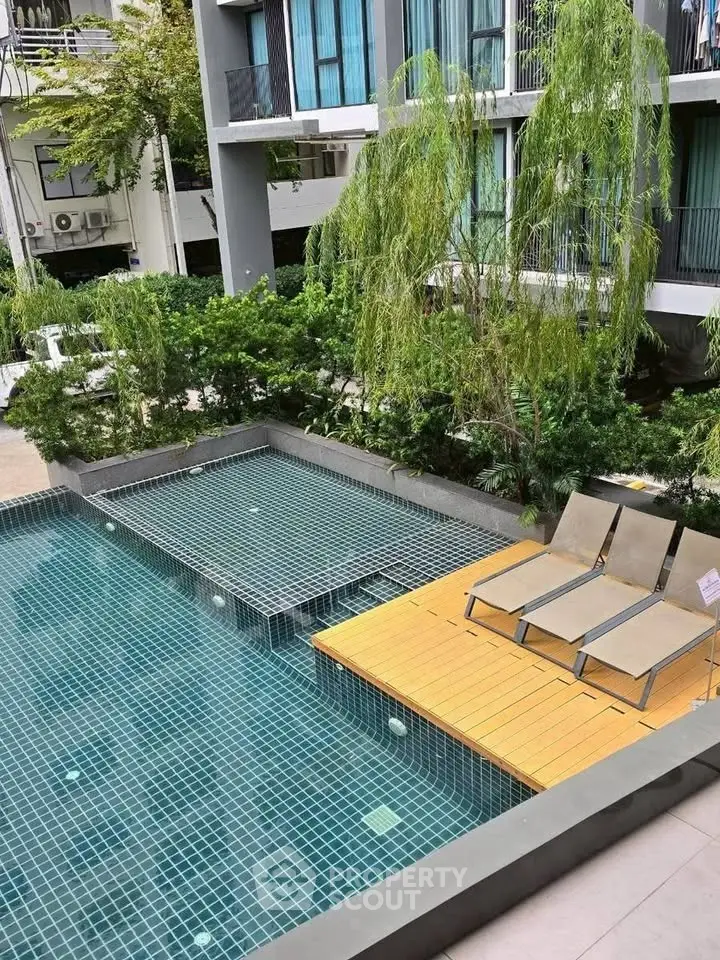 Modern apartment complex with stylish pool and lush greenery