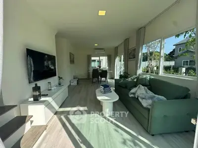 Spacious living room with modern decor and large windows offering natural light.