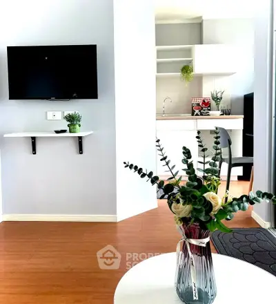 Modern living room with wall-mounted TV and stylish kitchen in open layout
