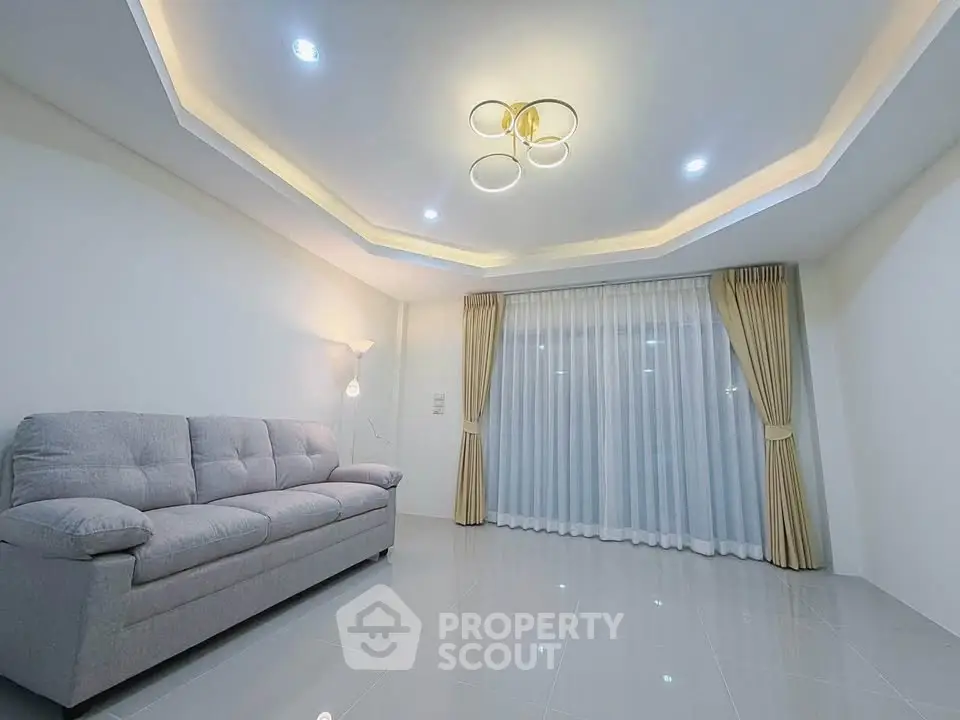 Spacious modern living room with elegant lighting and plush sofa, perfect for relaxation and entertaining.