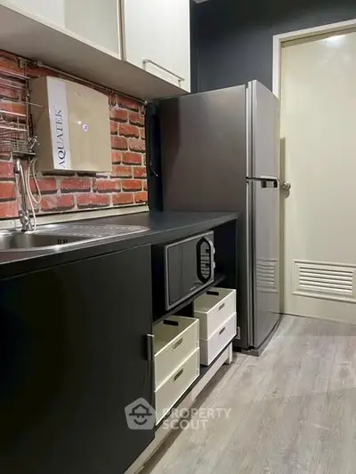 Modern kitchen with sleek black cabinets and stainless steel appliances