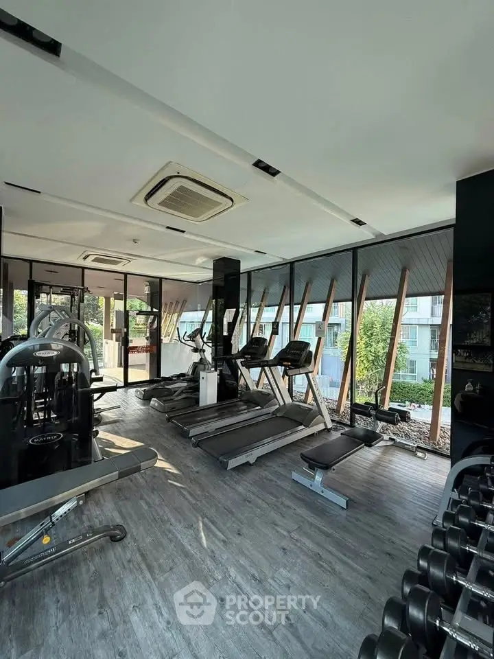 Modern gym with state-of-the-art equipment and large windows offering a scenic view.