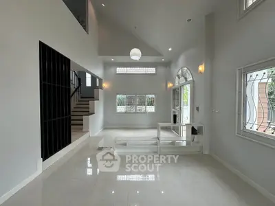 Spacious modern living room with high ceilings and elegant staircase