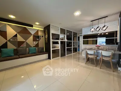 Modern open-plan living and dining area with stylish geometric wall design and elegant lighting.