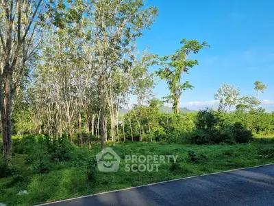 Scenic view of lush green landscape with trees and clear blue sky, ideal for real estate development.