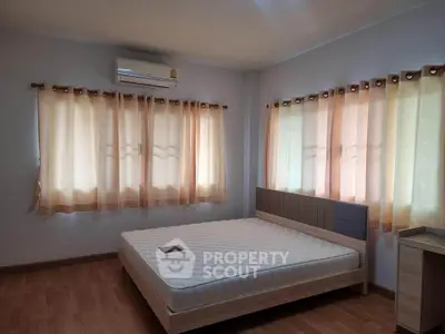 Spacious bedroom with natural light and modern furnishings