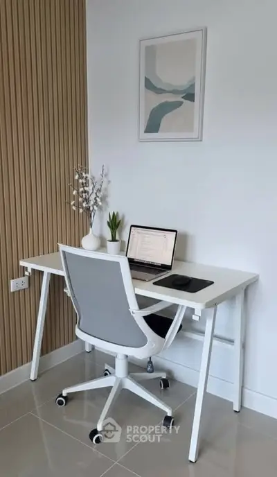 Modern home office setup with sleek white desk and ergonomic chair, perfect for productivity.