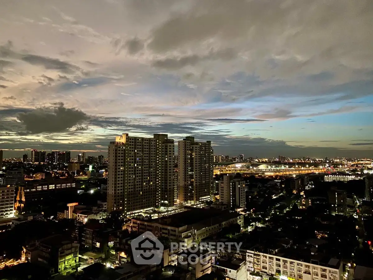 Stunning cityscape view from high-rise building at dusk, showcasing vibrant skyline and urban lights.
