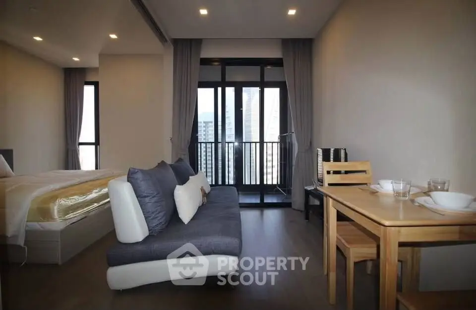 Modern studio apartment with cozy living area and balcony view