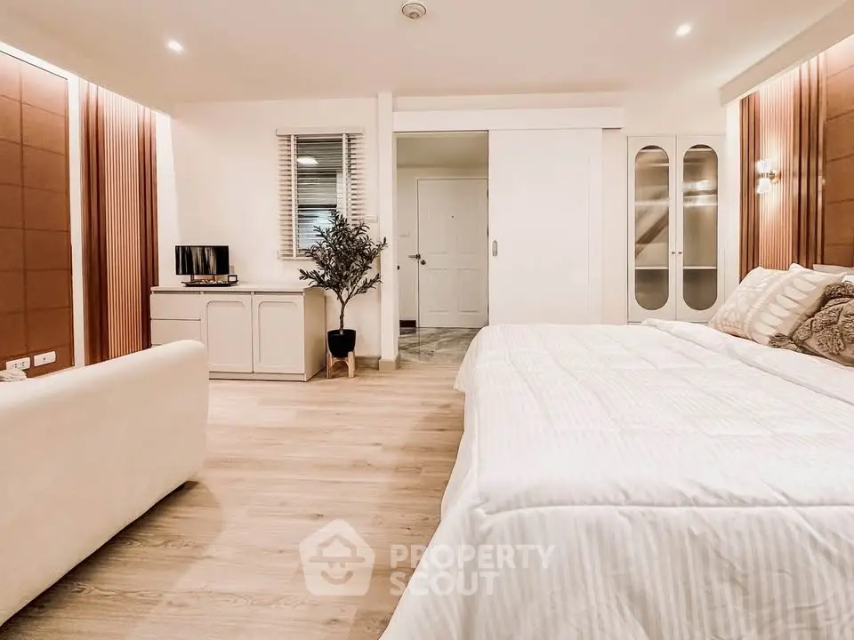 Spacious modern bedroom with cozy decor and natural lighting