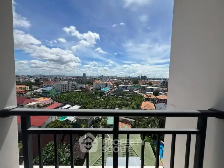 Stunning cityscape view from a high-rise balcony with clear blue skies.