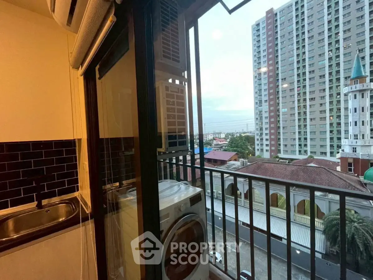 Charming apartment balcony with city view and laundry area, perfect for urban living.