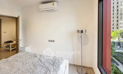 Modern bedroom with air conditioning and large window offering city view