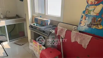 Compact kitchen area with sink and storage, featuring a window for natural light.