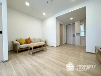 Spacious modern living room with wooden flooring and cozy sofa in a stylish apartment.