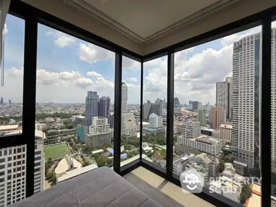 Stunning cityscape view from high-rise apartment bedroom with floor-to-ceiling windows