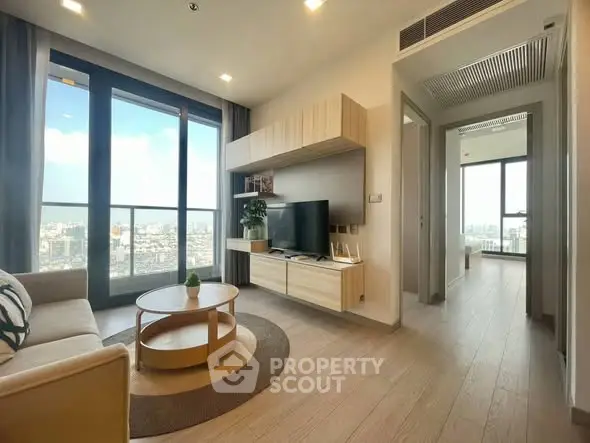 Modern living room with city view, stylish furniture, and natural light.