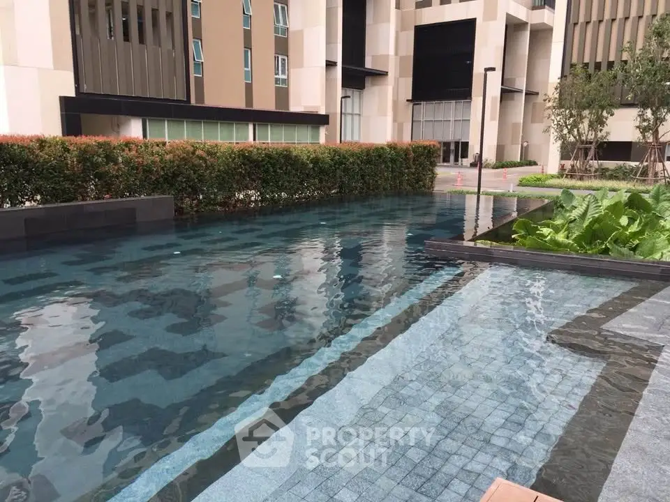 Luxurious modern building with serene pool and lush greenery