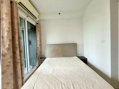 Cozy bedroom with natural light and modern decor, featuring a comfortable bed and air conditioning.