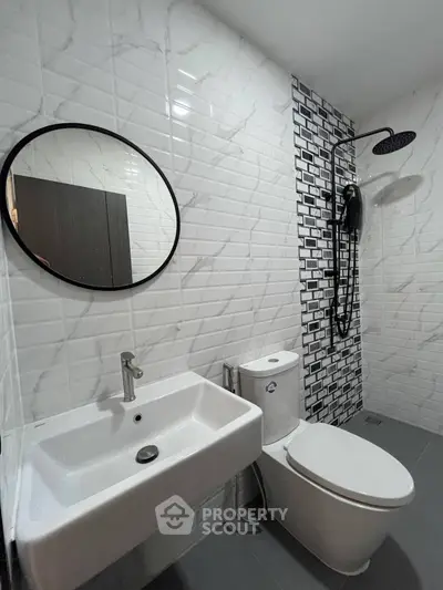 Modern bathroom with stylish tiles and round mirror