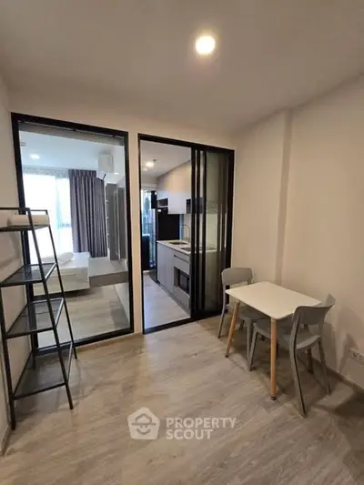 Modern apartment interior with open kitchen and dining area, featuring sleek design and ample natural light.