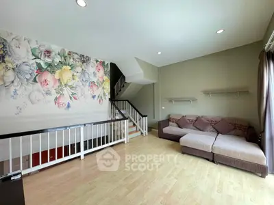 Spacious living room with floral accent wall and cozy sectional sofa