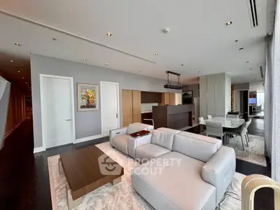 Luxurious modern living room with sleek furniture and open kitchen layout.