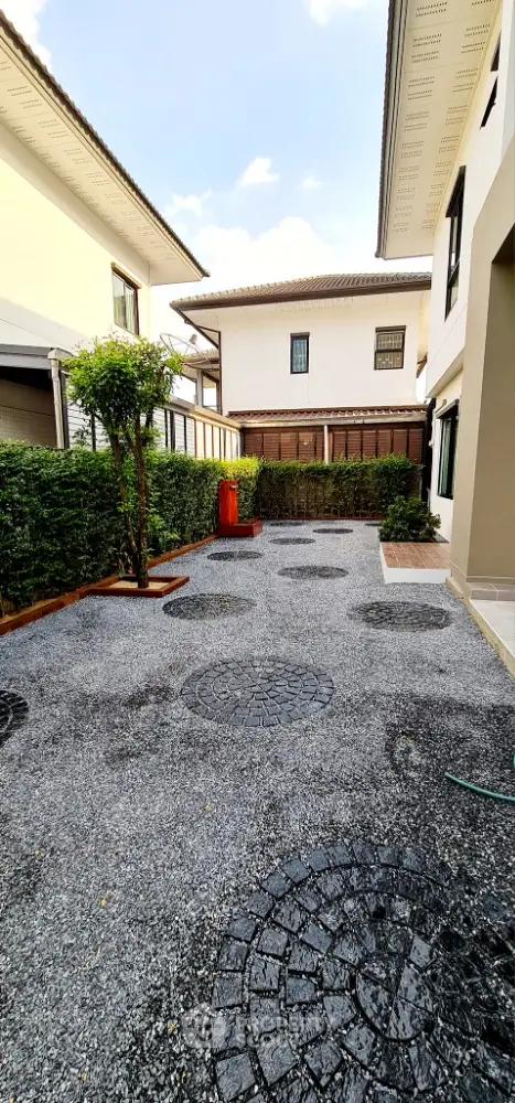 Spacious modern garden area with stylish paving and lush greenery in a contemporary home setting.