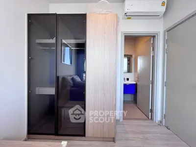 Modern bedroom with sleek wardrobe and view into stylish bathroom