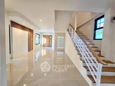 Spacious modern living room with elegant staircase and large windows