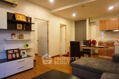 Modern open-plan living room and kitchen with stylish decor and wooden flooring.