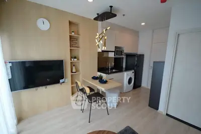 Modern kitchen with integrated appliances and stylish dining area in open layout.