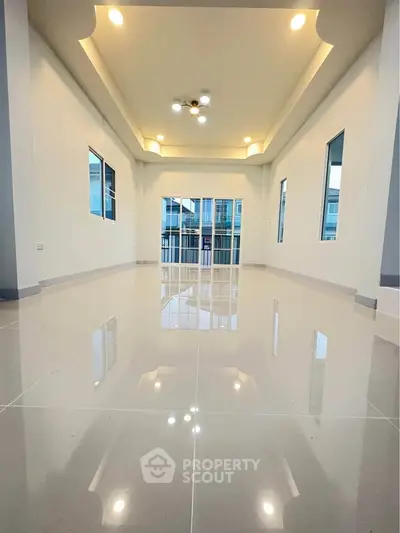 Spacious modern living room with glossy tile flooring and elegant ceiling lights.