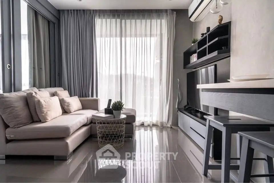 Modern living room with sleek furniture and large windows offering natural light.