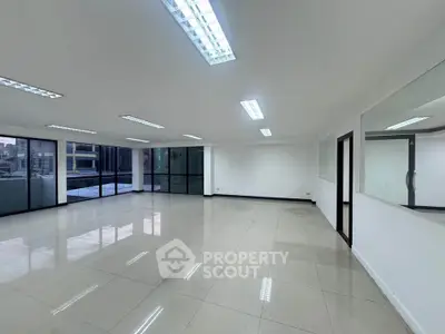 Spacious modern office space with large windows and tiled flooring