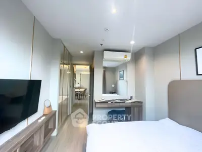 Modern bedroom with sleek design, featuring a wall-mounted TV, air conditioning, and stylish furnishings.
