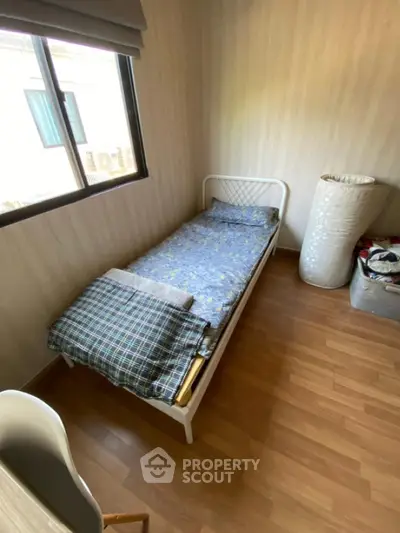 Cozy small bedroom with single bed and wooden flooring