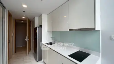 Modern kitchen with sleek white cabinets and glass backsplash