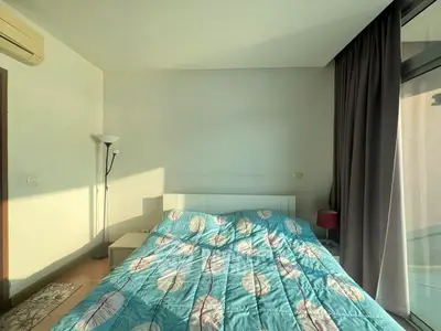 Cozy bedroom with modern decor and large window for natural light.