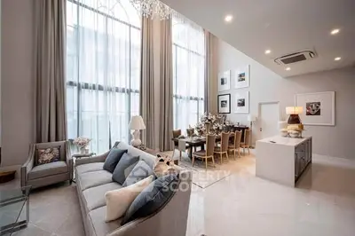 Luxurious modern living room with high ceilings and elegant decor in a spacious open-plan layout.