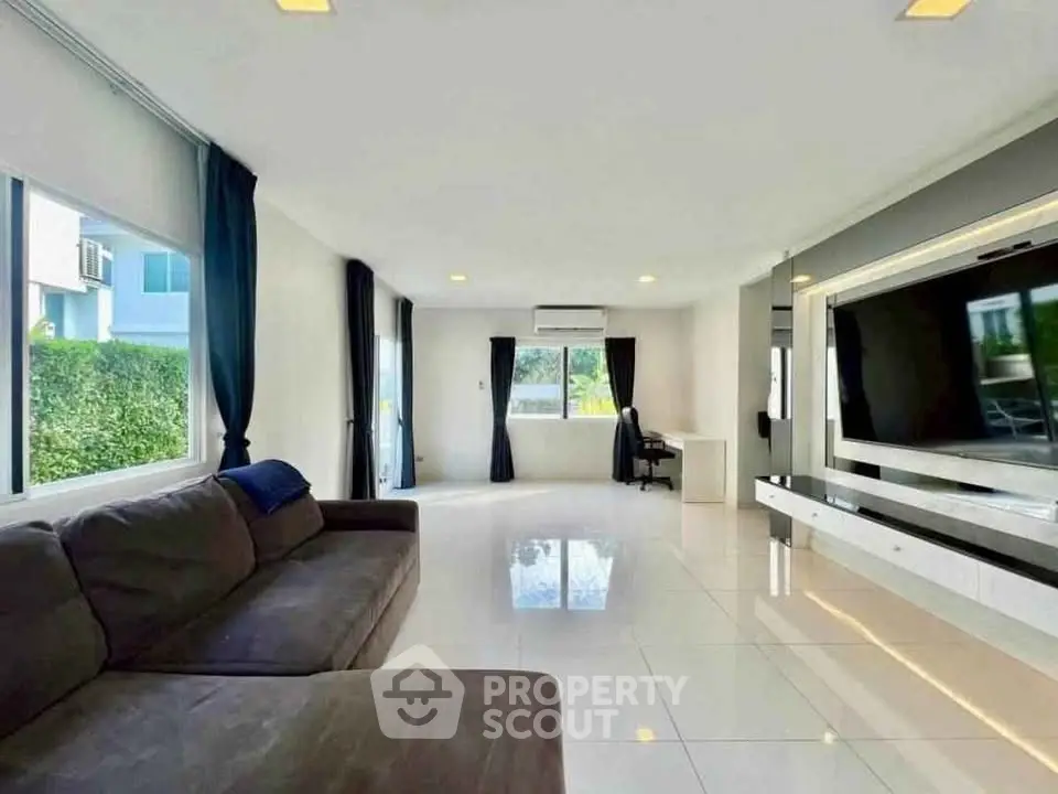 Spacious modern living room with large windows and sleek entertainment center