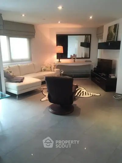 Modern living room with stylish decor, featuring a cozy sectional sofa and elegant lighting.