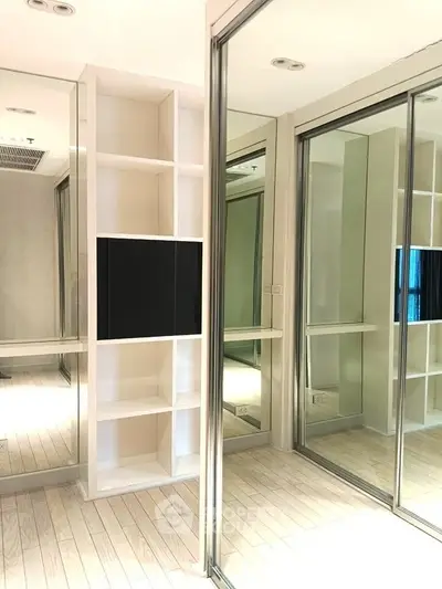 Modern interior with mirrored sliding doors and built-in shelving unit